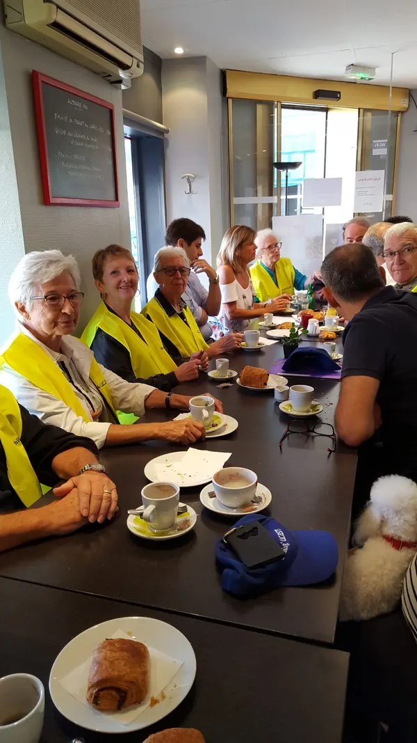 Un groupe réuni autour d'un petit déjeuner au P'tit Café